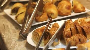 A buffet with various baked goods and pastries.