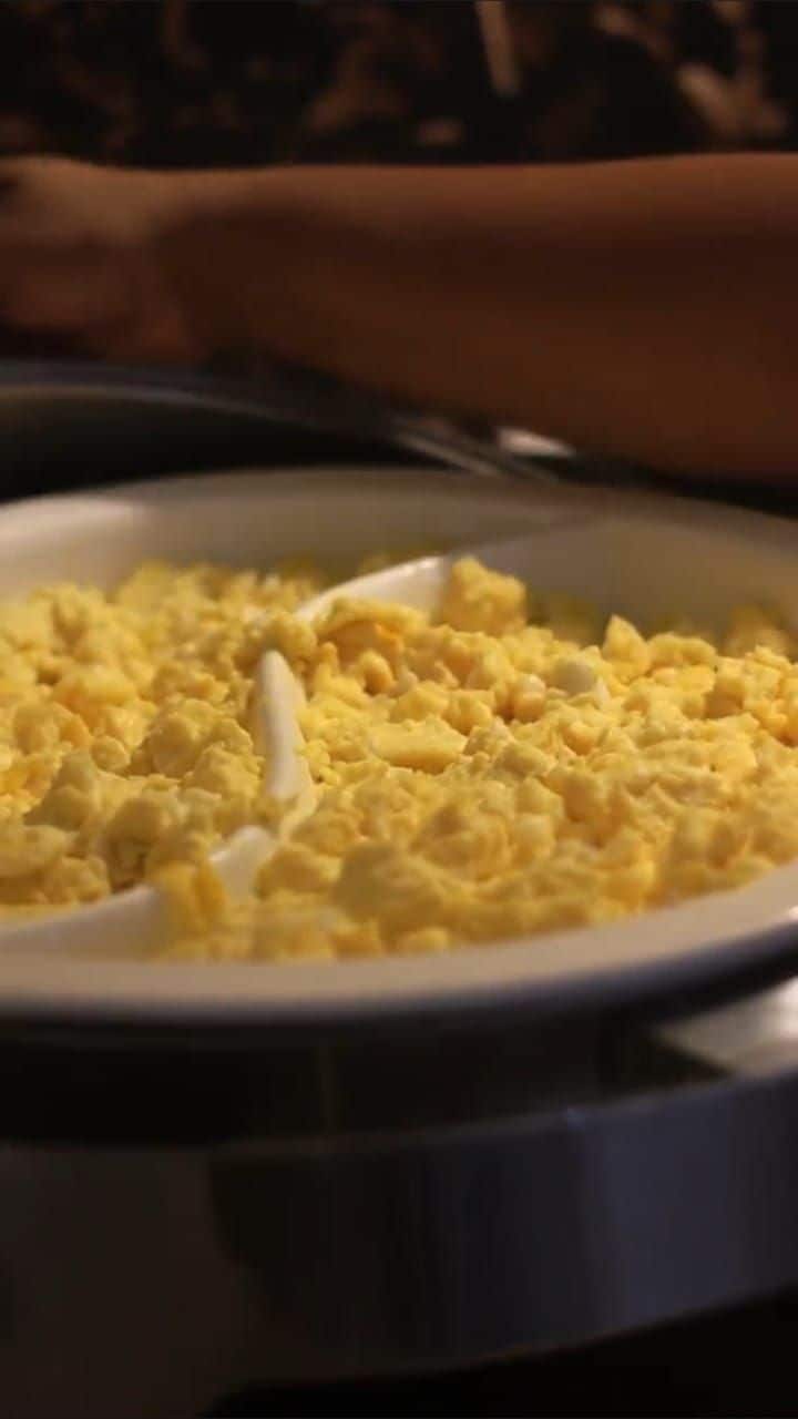 A close-up of scrambled eggs in a white bowl.