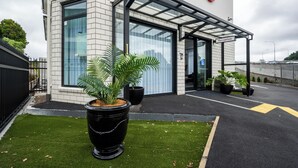 Un edificio moderno con área de recepción, ventanas amplias y plantas en macetas.