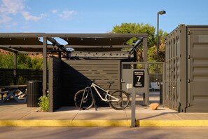 A bicycle parked under a covered bike rack with a sign indicating reserved parking. - Slackline Moab, Outset Collection by Hilton (Moab)