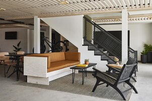 Un interior moderno con un sofá, una mesa de comedor y una escalera.