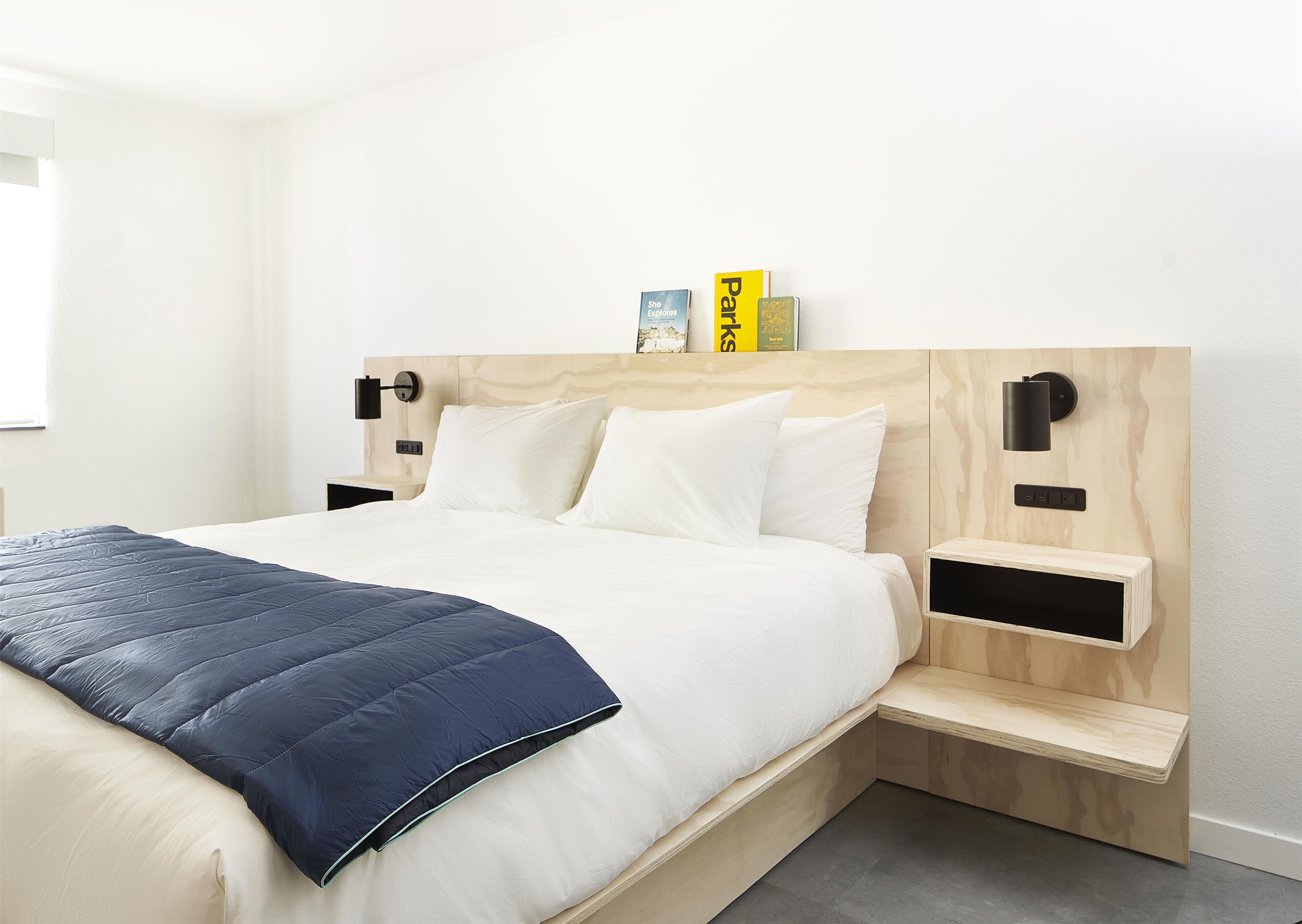 A modern bedroom with a bed, bedside tables, and a nightstand.