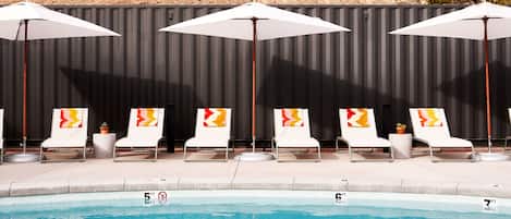 Een buitenzwembad, parasols voor strand/zwembad