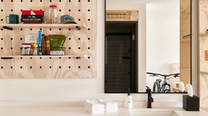 A bathroom with a wooden pegboard wall, a sink, and a mirror. - Slackline Moab, Outset Collection by Hilton (Moab)