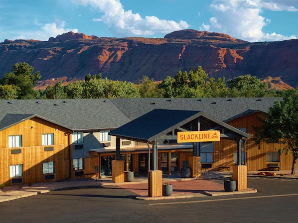 A modern building with a sign reading 'SLACKLINE MPAB' in front of a mountainous landscape. - Slackline Moab, Outset Collection by Hilton (Moab)