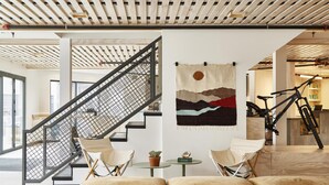 A modern interior with a staircase, seating area, and artwork.