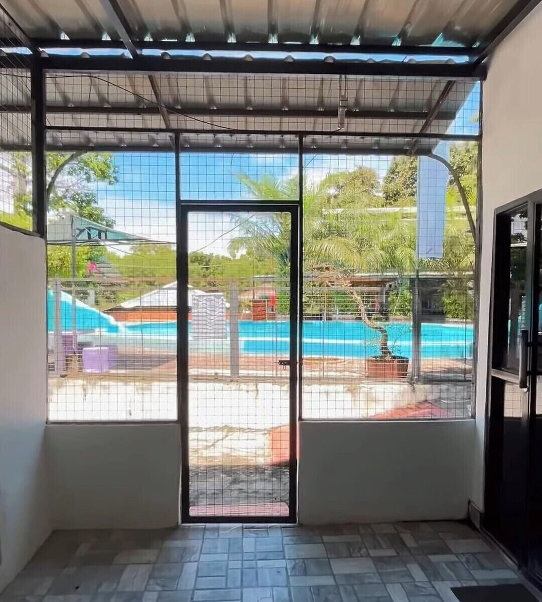 A room with a view of an outdoor swimming pool, a door, and a tiled floor.