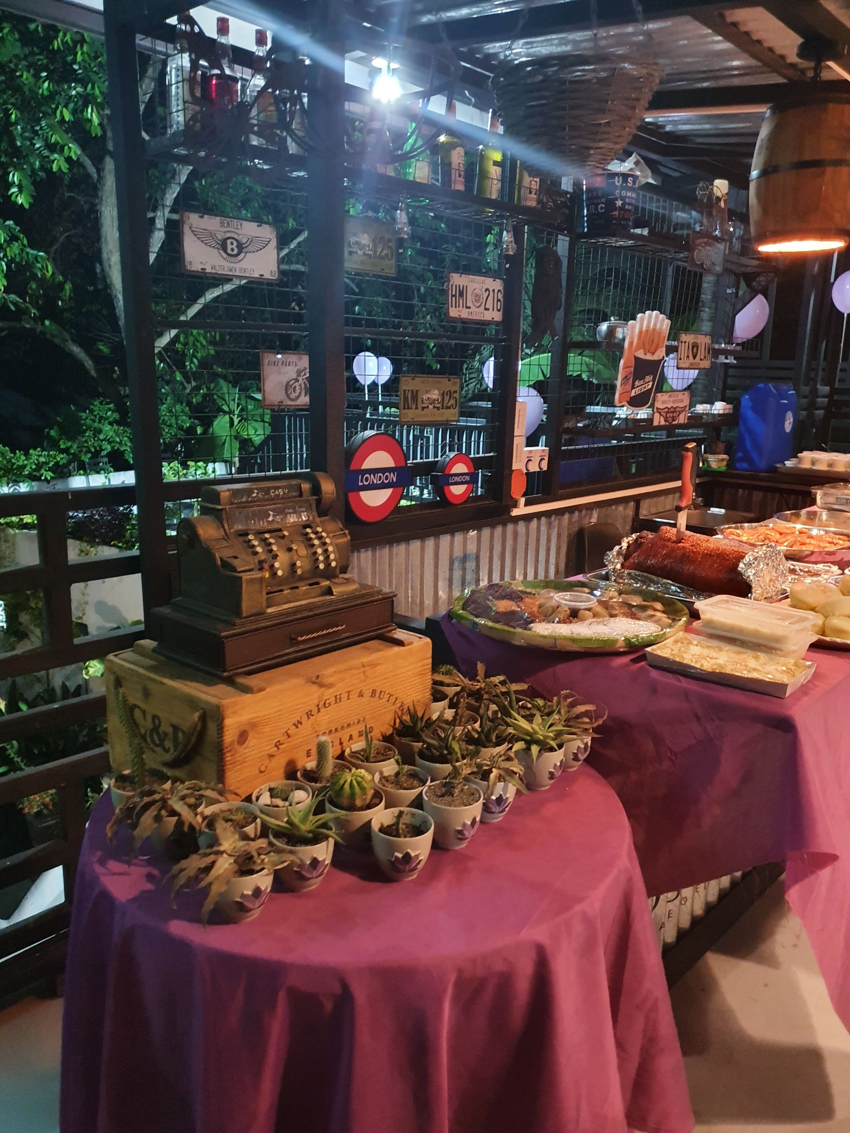 A table with various food items and a vintage cash register.