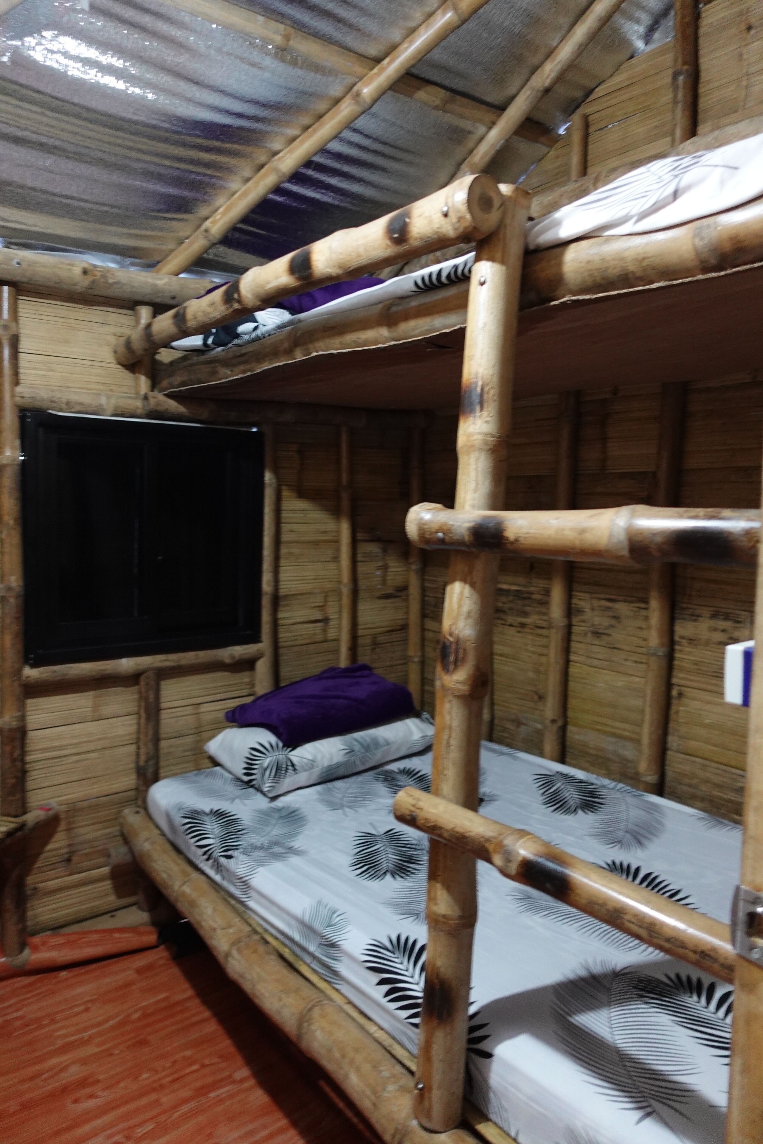 A bunk bed with a wooden frame and a mattress with a leaf pattern.