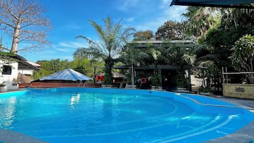 Una piscina con superficie de agua azul cristalina, rodeada por una solana de piedra.