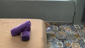 Habitación de hotel con cama, ventana con vista a una piscina, televisor y piso con diseño.