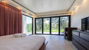 Un dormitorio moderno con una cama grande, un escritorio y un televisor.