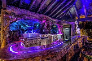 Un espace bar au décor rustique, avec un mur en pierre et des poutres en bois.