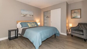 A bedroom with a bed, bedside tables, a wardrobe, and a chair. - Welcome to the Lakeside Suite! Enjoy! (Fairport Harbor)