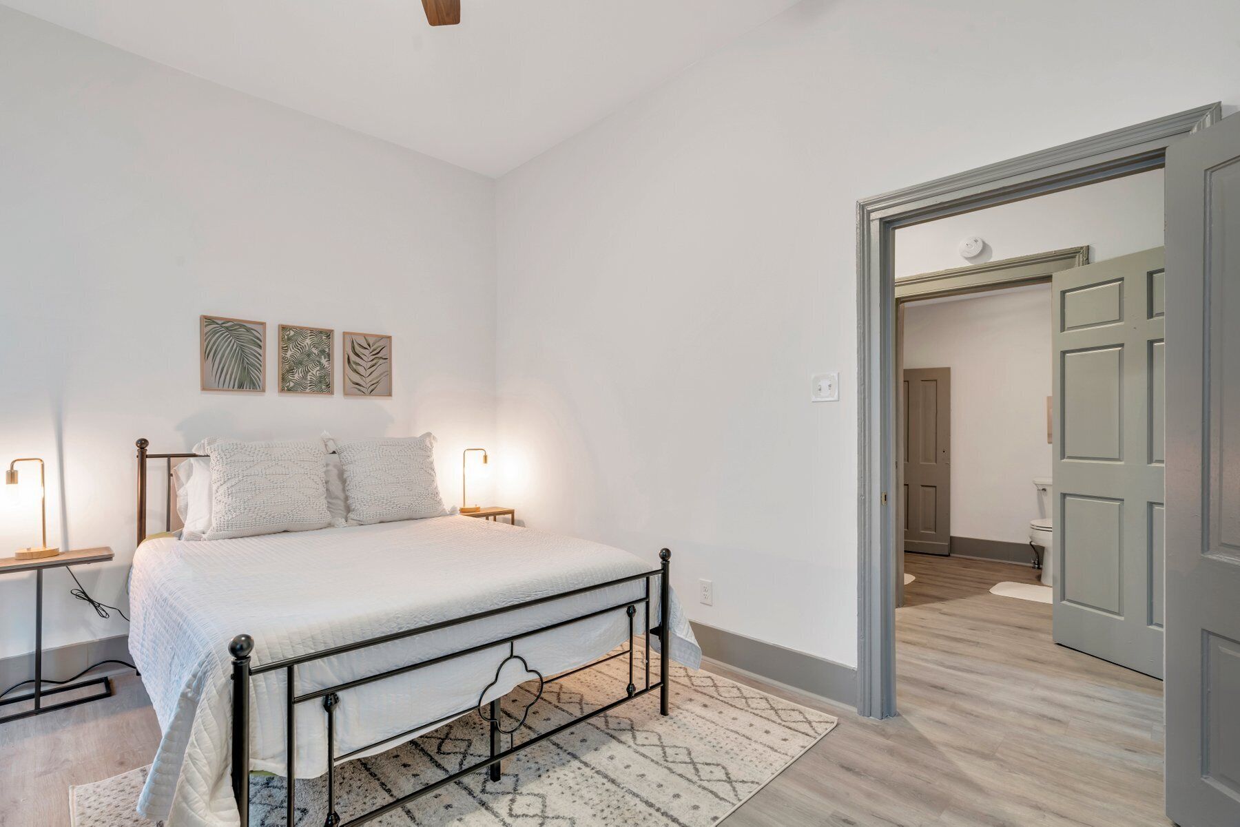 Une chambre à coucher avec un lit, des lampes de chevet et un tapis.