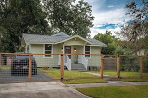 Set amidst a residential area, this charming home features a gabled roof and a welcoming front porch.