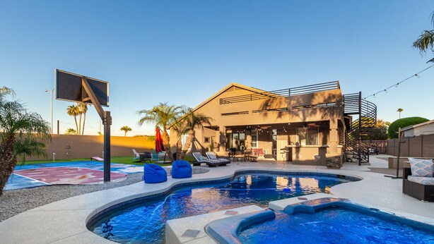 A modern house with a swimming pool, outdoor seating, and a basketball court. - Phoenix Vacation Home -- Pool, Spa, Basketball & Putting Green (Phoenix)