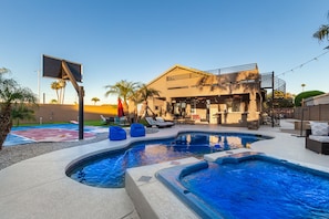 Uma casa moderna com piscina, área de estar externa e quadra de basquete.