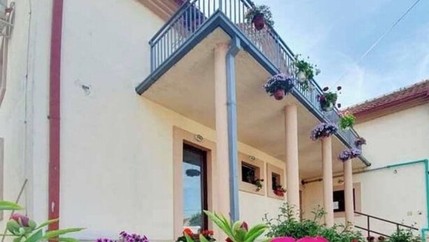 Un bâtiment doté d’un balcon, d’une porte et d’une fenêtre.