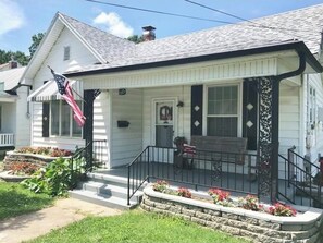 Stylish single-story home with a charming front porch and well-manicured lawn.