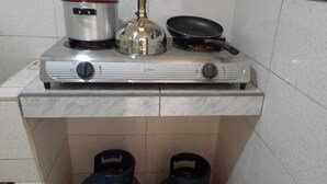 A kitchen with a gas stove, a frying pan, and two kettles. - Beautiful, central and economical apartment (Rímac)