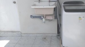 A bathroom with a white sink, a toilet, and a white washing machine. - Beautiful, central and economical apartment (Rímac)