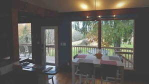 A dining area with a table and chairs, a window with a view of the outdoors, and a door leading to another room. - Sweet and spacious mountain view home w/fireplace! (Gardiner)