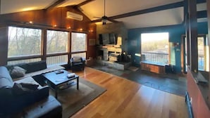 A spacious living room with large windows, a fireplace, and a balcony. - Sweet and spacious mountain view home w/fireplace! (Gardiner)