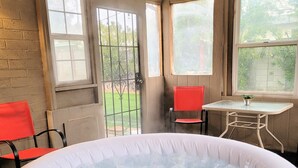 A hot tub in a room with a brick wall, a window, and a red chair. - Spacious 4-bedroom Scottsdale house w/pool, hot tub, billiards in great location (Scottsdale)