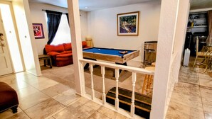 A billiards table in a room with a red sofa and a painting on the wall. - Spacious 4-bedroom Scottsdale house w/pool, hot tub, billiards in great location (Scottsdale)