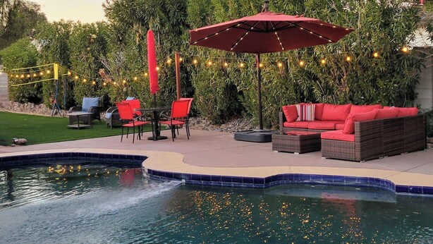 A backyard with a swimming pool, outdoor furniture, and string lights. - Spacious 4-bedroom Scottsdale house w/pool, hot tub, billiards in great location (Scottsdale)