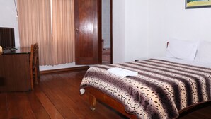 A bedroom with a wooden bed, a desk, and a chair. - Hostal La Catolica (Quito)