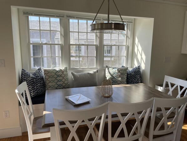 Enjoy meals in this inviting dining area with a round table, woven candle holder, and comfortable seating.