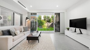 A modern living room with a sofa, coffee table, and TV.