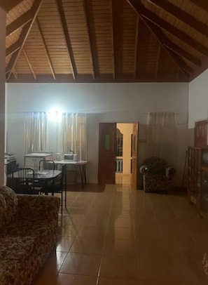Un vaste salon doté d’un haut plafond et d’un coin repas situé à l’arrière.