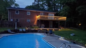 A swimming pool with a covered patio area, a brick house, and a lawn. - Homemade in HICKORY! Salt Water Pool!  (Hickory)