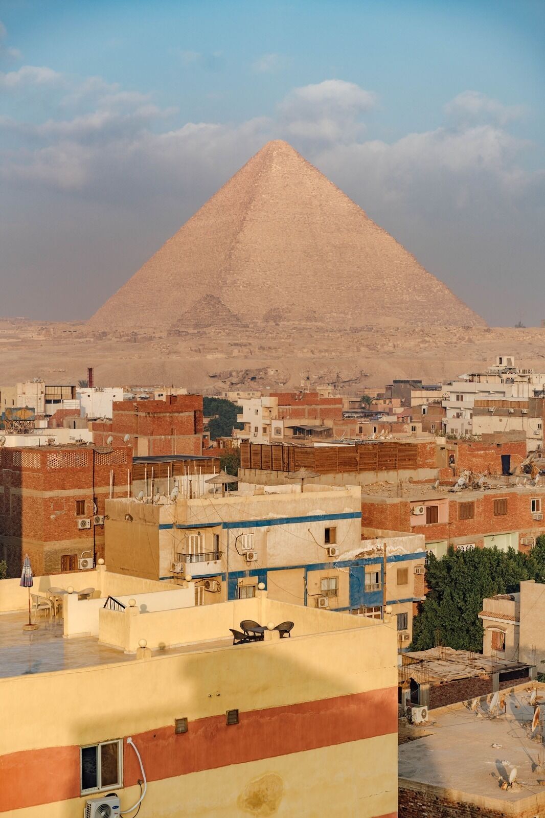 Une pyramide en arrière-plan et un paysage urbain au premier plan.