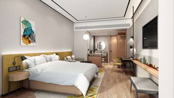 A modern hotel room with a large bed, bedside table, and a desk with a chair.