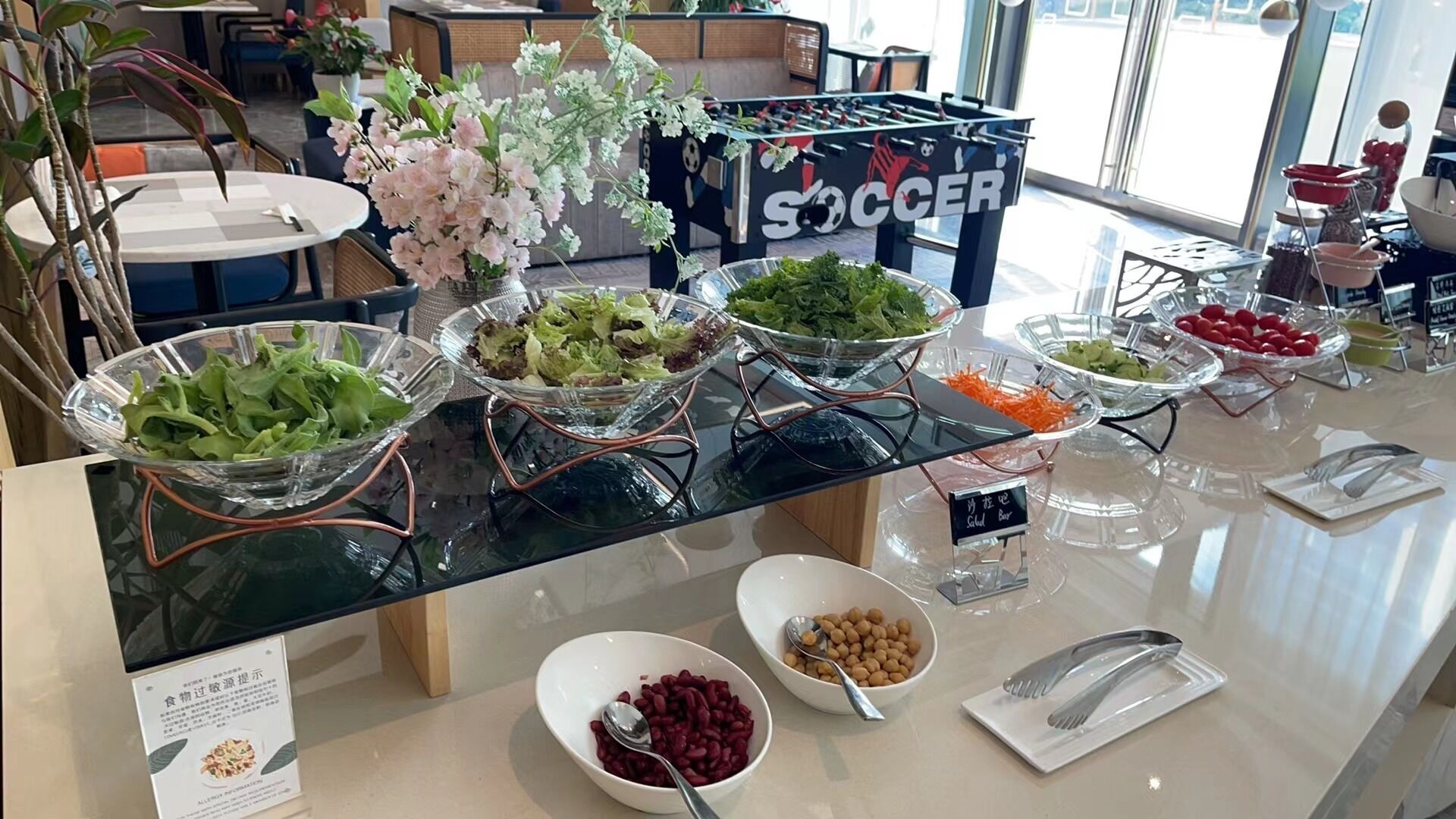 Un buffet con diverse opzioni gastronomiche, tra cui insalate, fagioli e frutta.