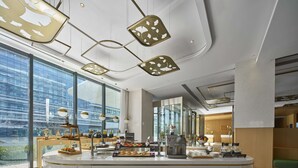 A modern kitchen area with a central island, large windows, and contemporary lighting fixtures.