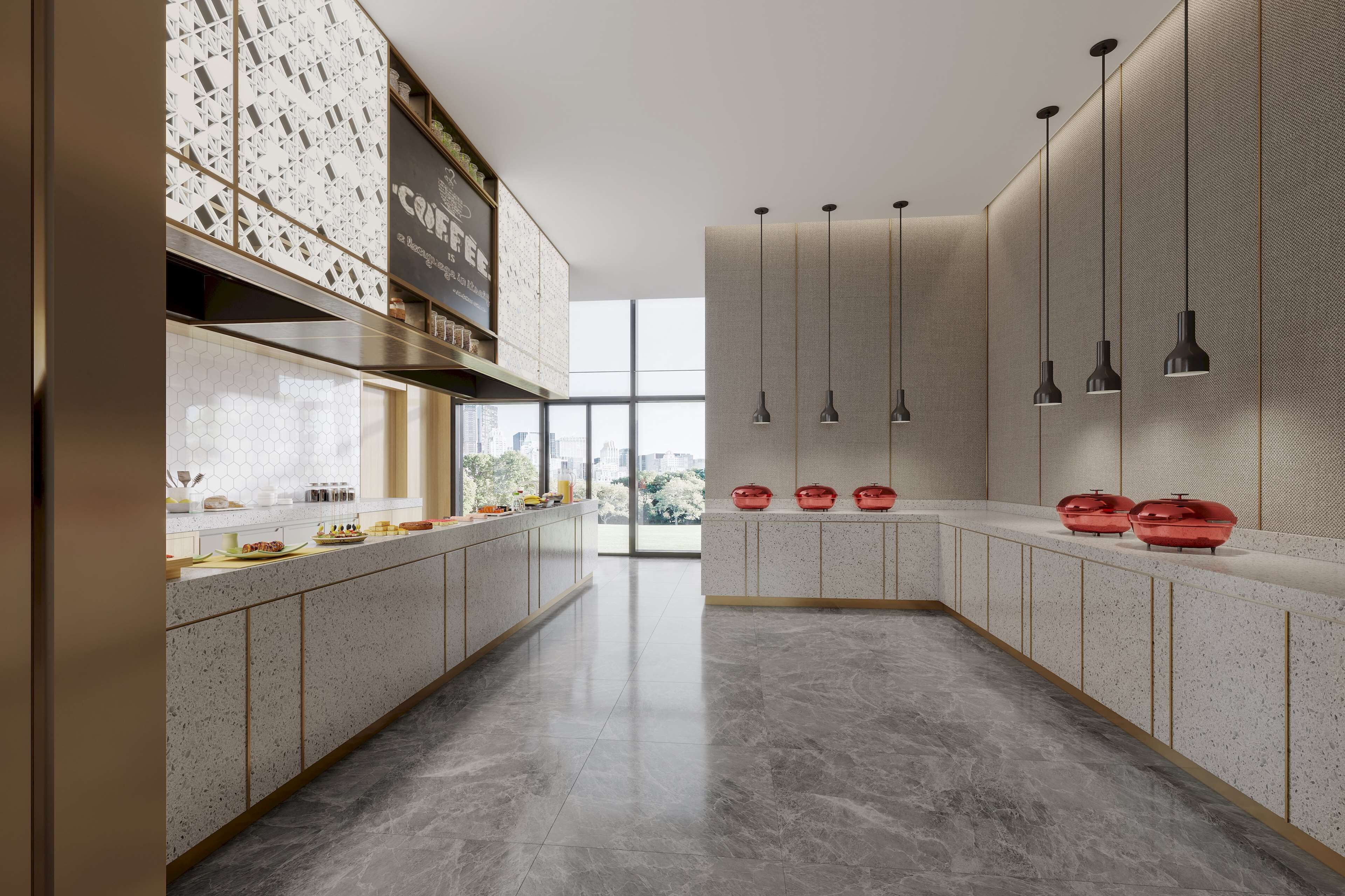 A modern kitchen with a long counter, pendant lights, and a view of the city through large windows.