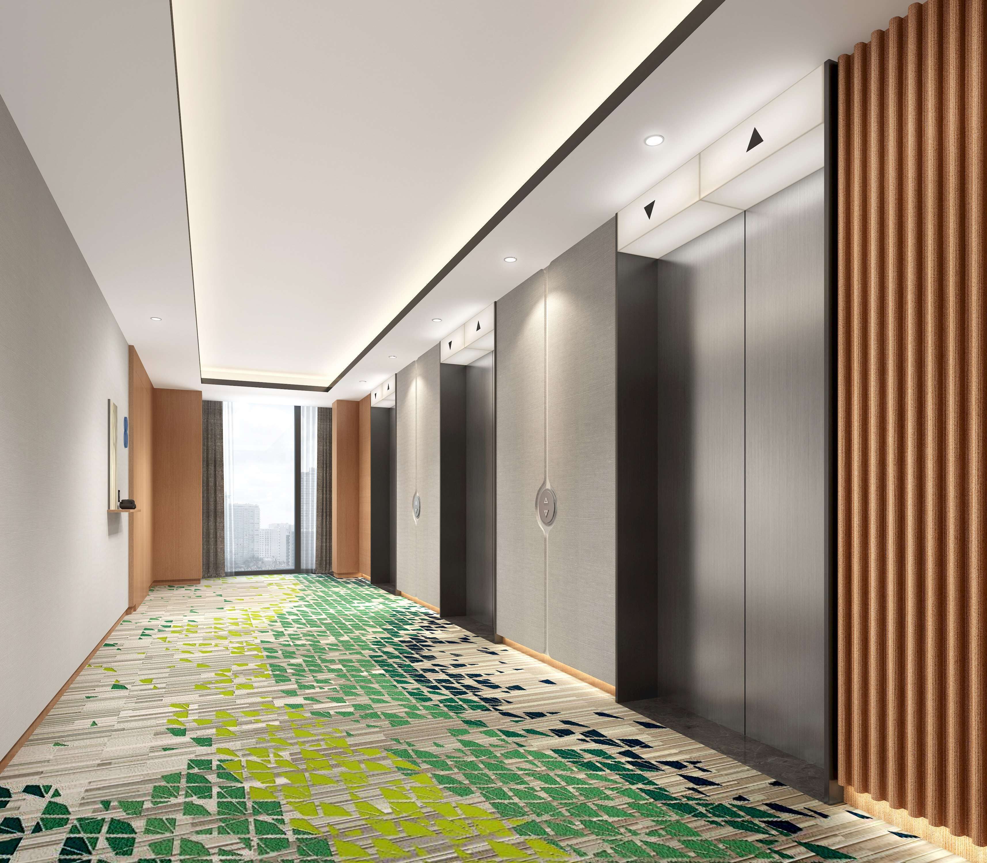 A modern hallway with patterned flooring, recessed lighting, and a view of a cityscape through large windows.