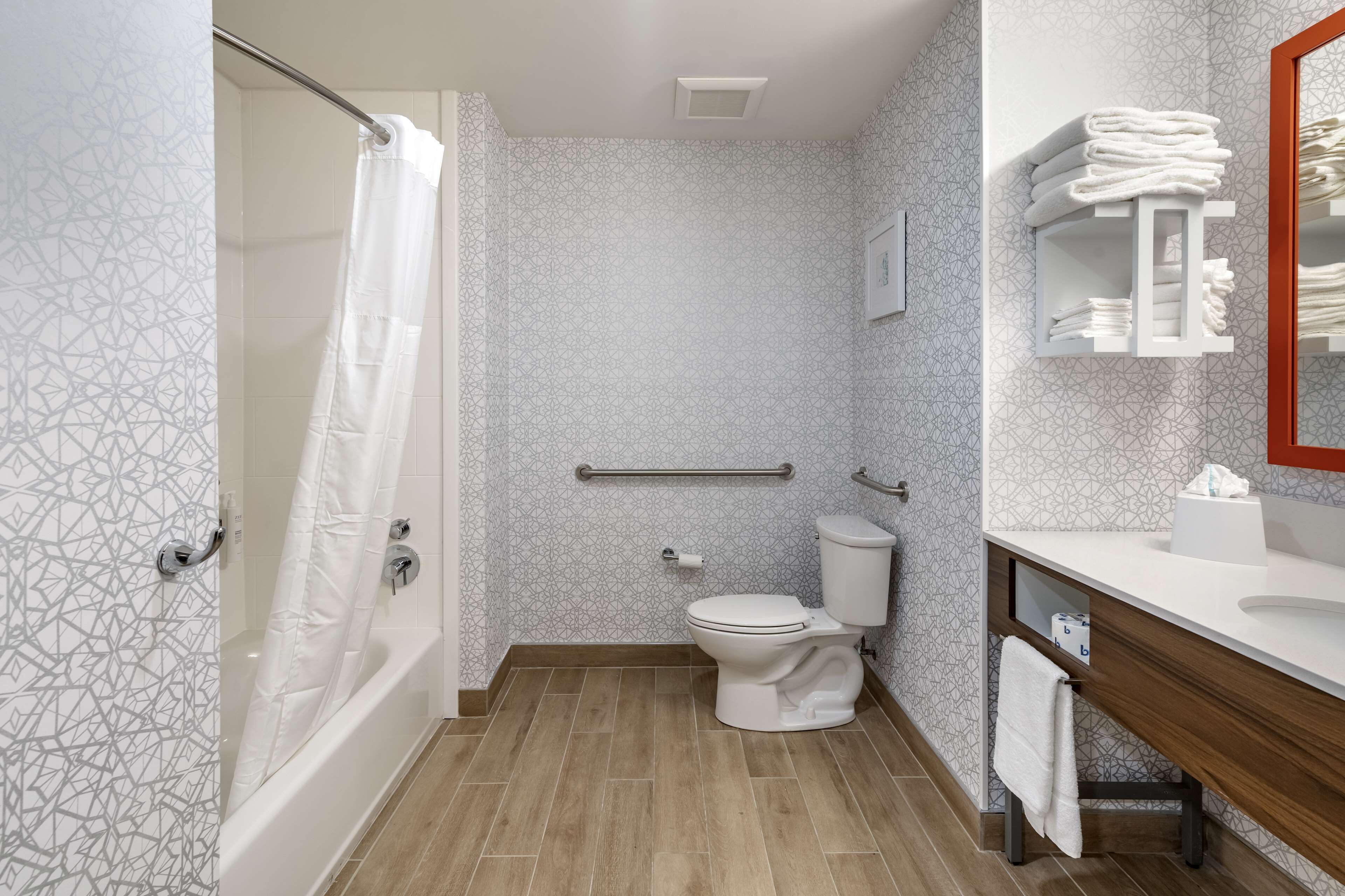 Un baño con ducha, inodoro y tocador.