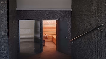 A modern interior with a dark brick wall, a wooden bench, and a glass door leading to a room.