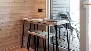 A wooden-paneled room with a table and chairs, a window, and a door.