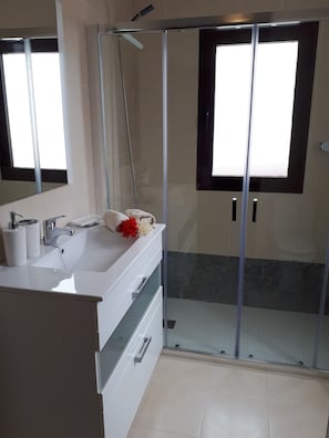 Een douche, een haardroger, handdoeken, toiletpapier