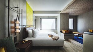 A modern hotel room with a large bed, a desk, a chair, and a view of the city. - voco Osaka Central by IHG (Osaka)