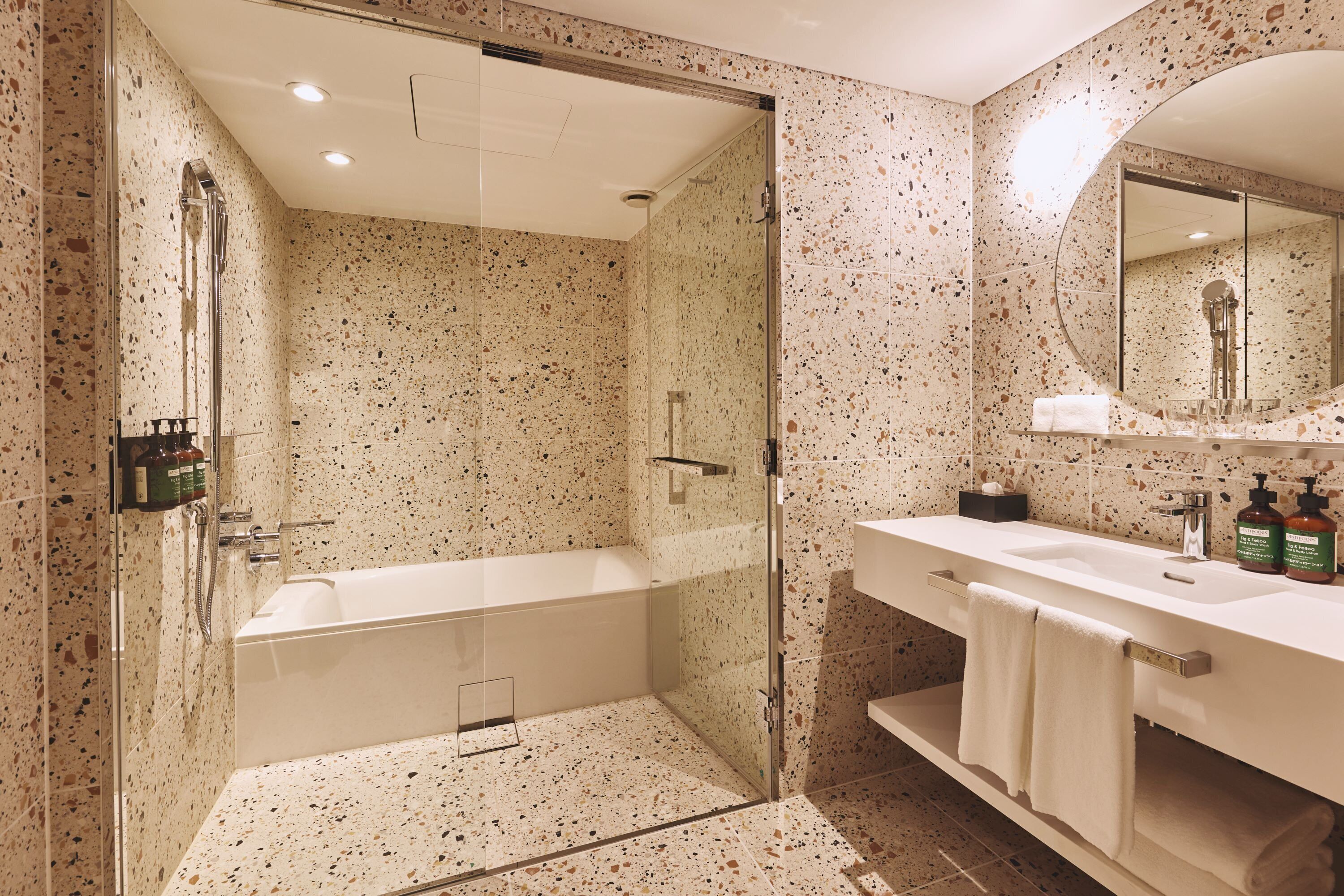 Une salle de bain moderne avec une baignoire sur pieds, une douche à parois de verre et un meuble-lavabo avec un miroir.