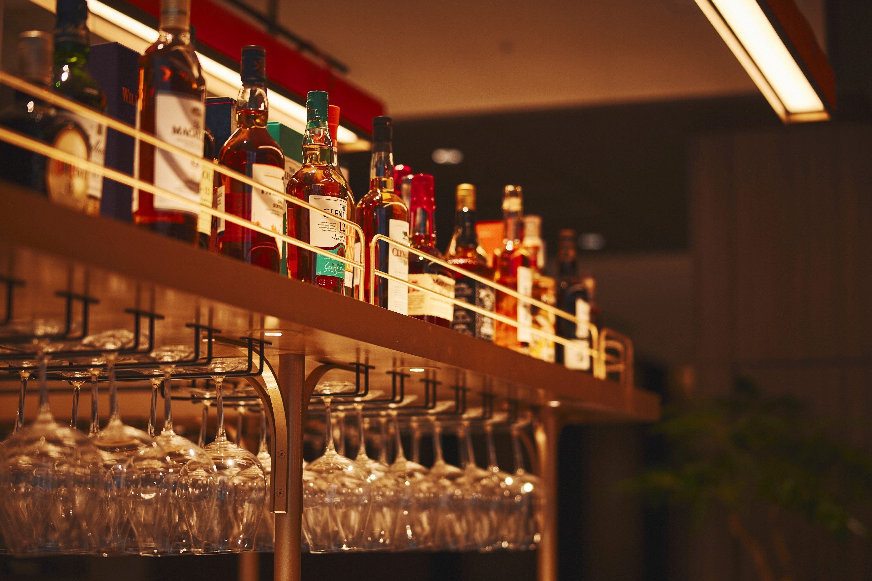 A bar area with shelves of liquor bottles and glasses.