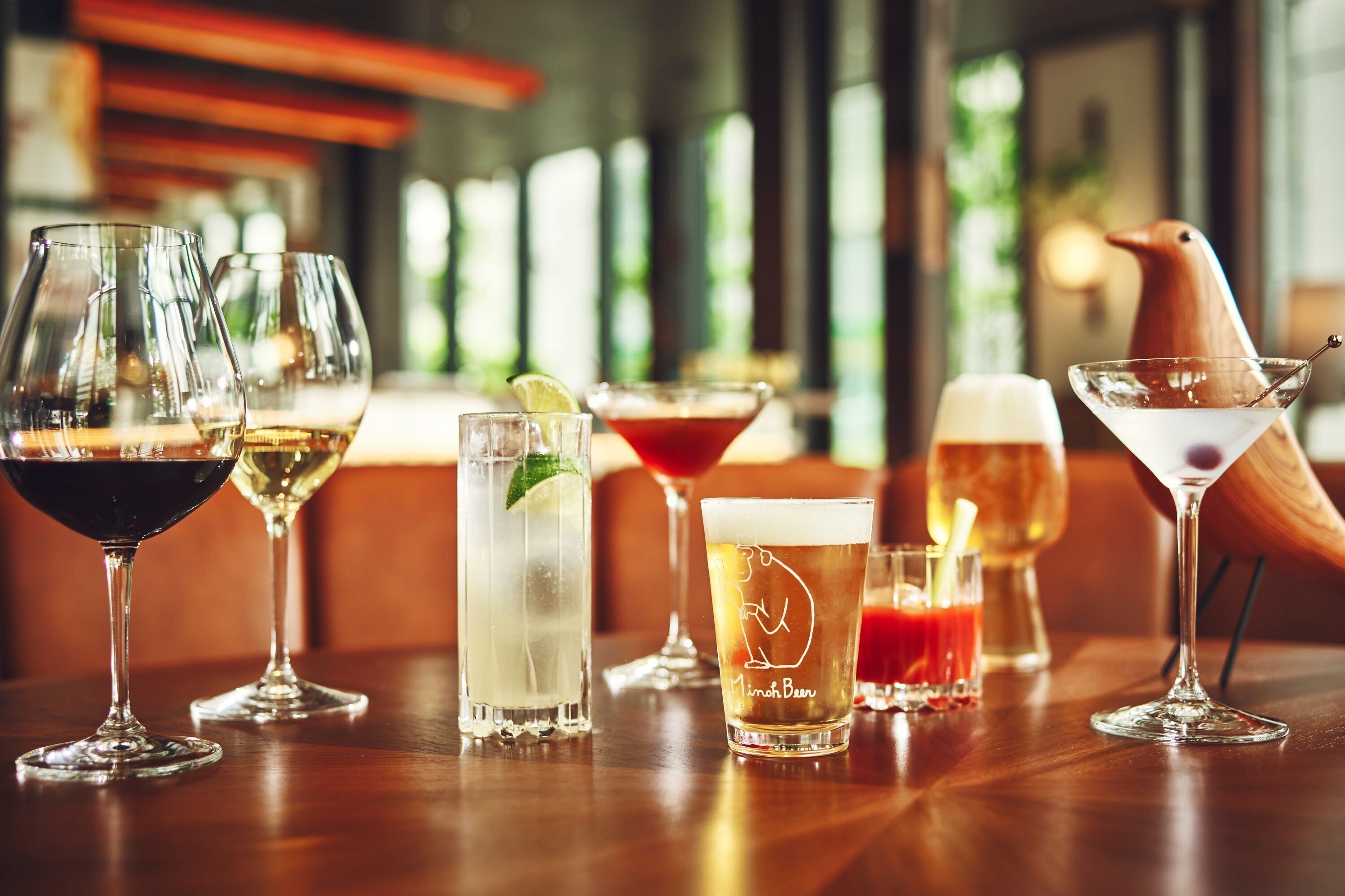 A variety of drinks on a wooden table in a well-lit indoor setting.
